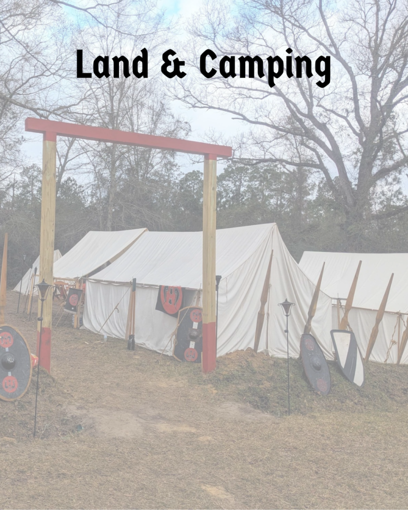 The entrance to a camp of canvas wall tents that features a wooden arch as the gate with spears and shields as the fence. The words "Land and Camping" are across the top. 